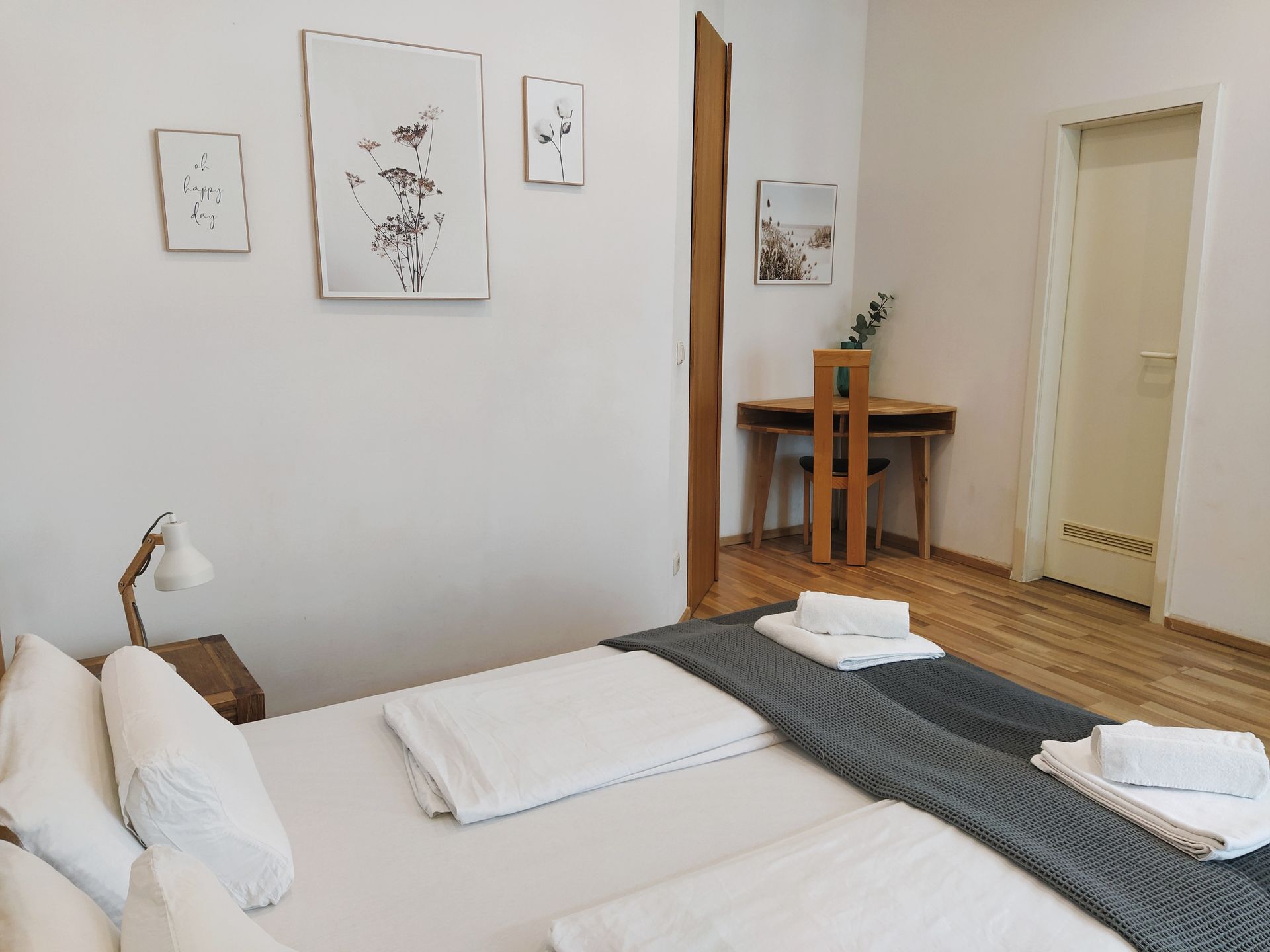 Schlafzimmer mit zwei Betten, einem Schreibtisch in unserer Fewo im Prenzlauer Berg.