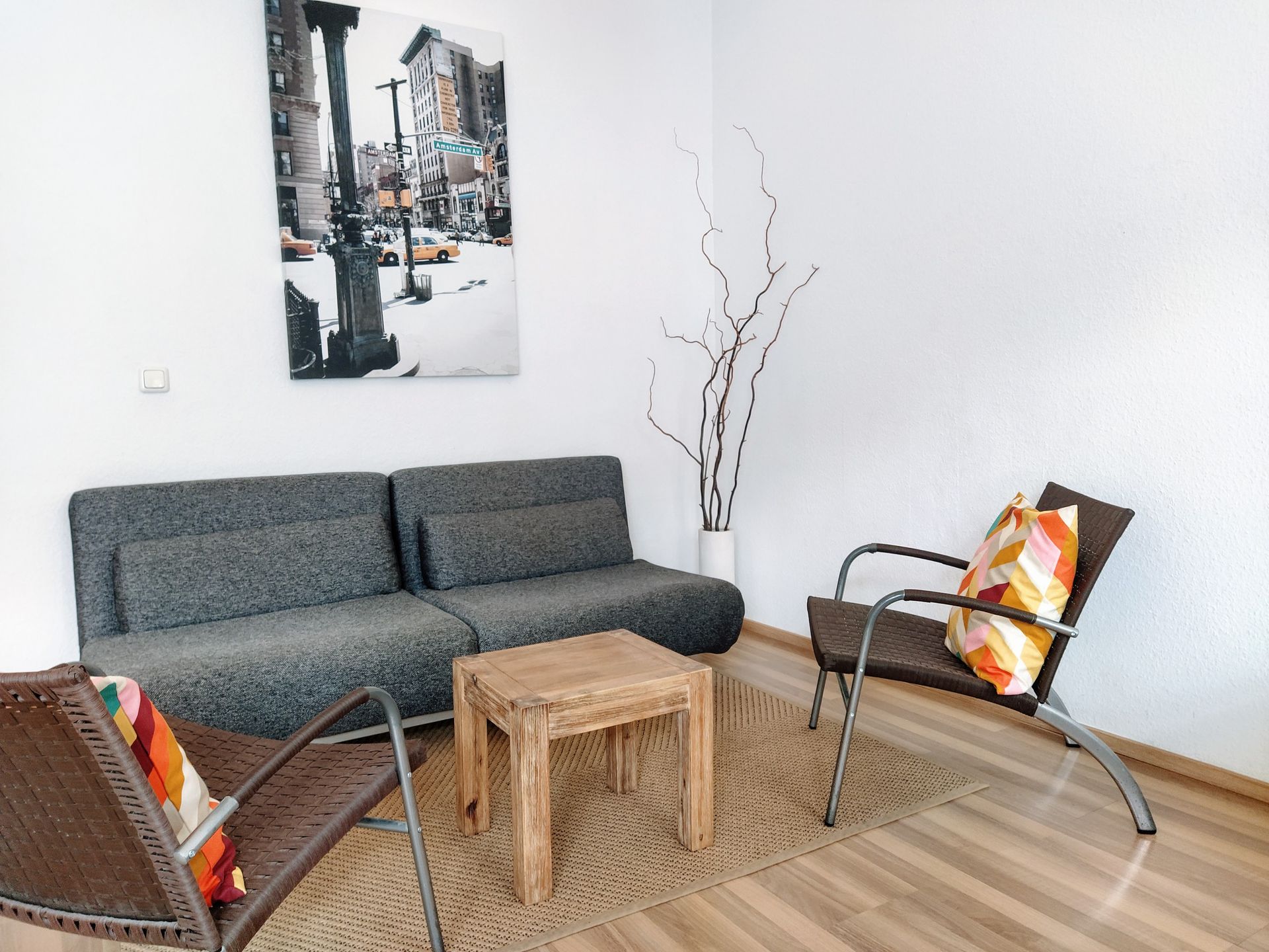 A living room with a couch , chairs , a table and a painting on the wall in our Berlin vacation rental