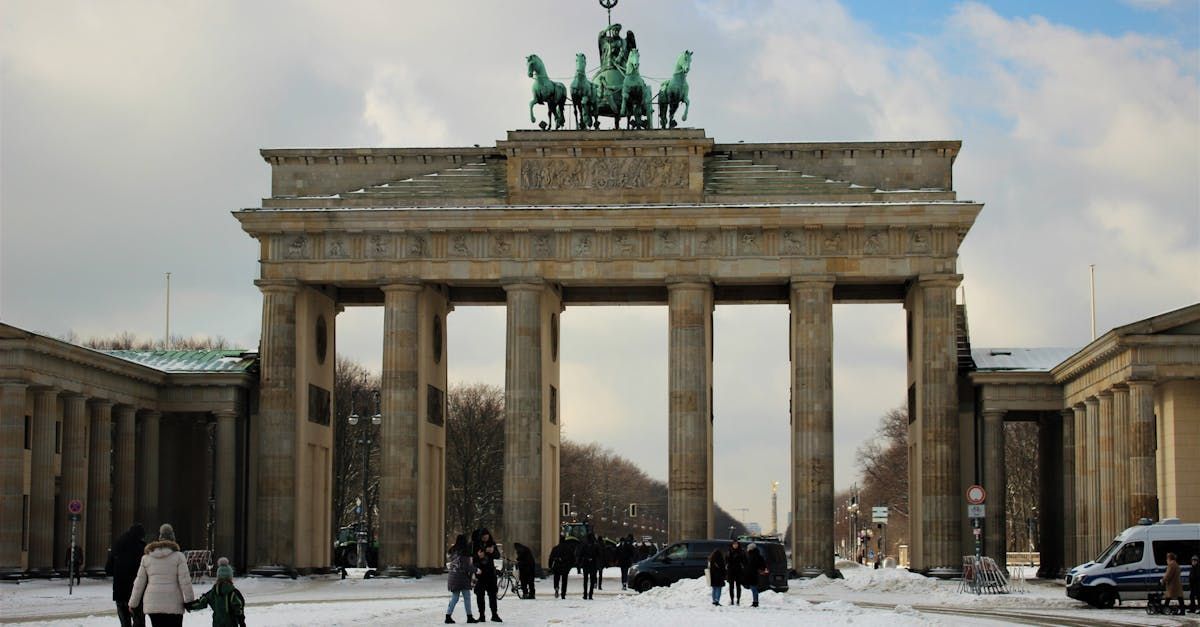 Eine Gruppe von Menschen steht vor Brandenburger Tor in Berlin im Schnee.