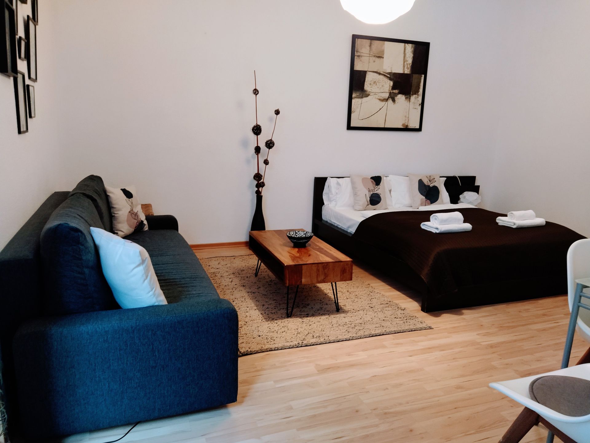 A living room with a couch , bed , coffee table and chairs in our holiday rental in Berlin close to the Mauerpark