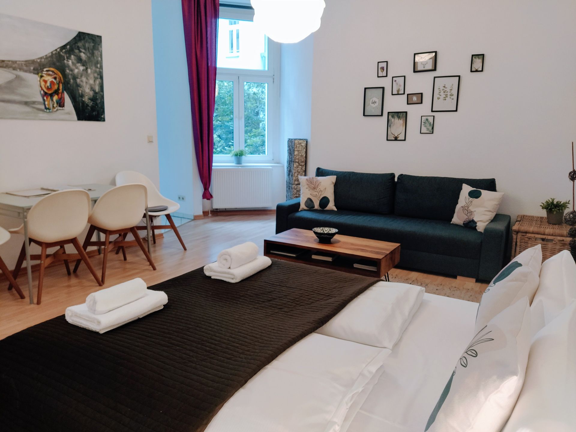 A living room with a bed , couch , table and chairs in our vacation rental in Berlin close to the Mauerpark
