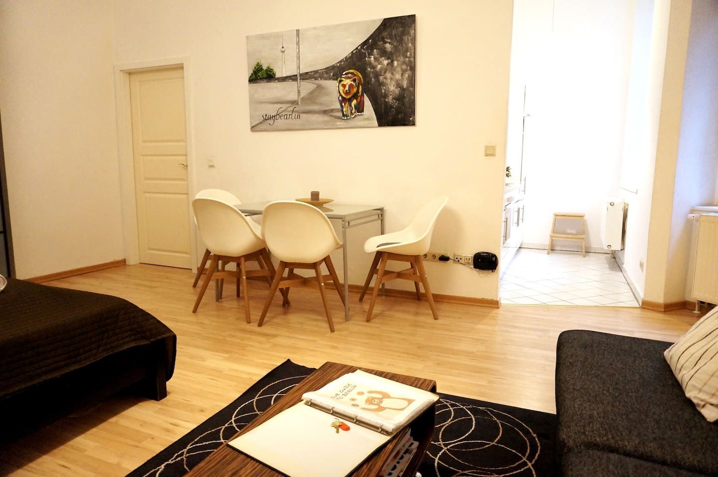 A living room with a couch , table , chairs and a painting on the wall in our holiday rental in Berlin close to the Mauerpark