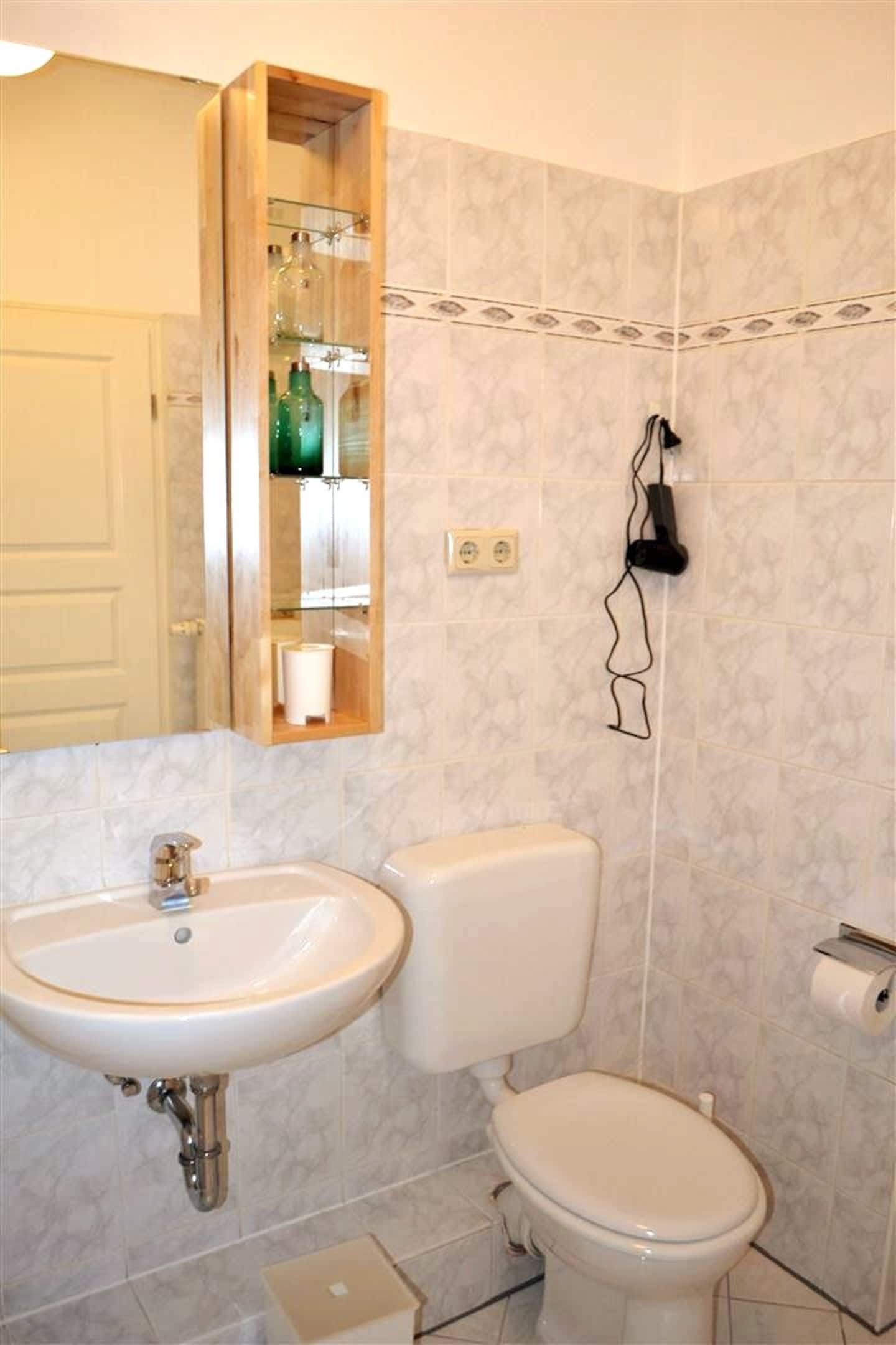 A bathroom with a sink toilet and mirror  in our holiday apartment in Berlin close to the Mauerpark