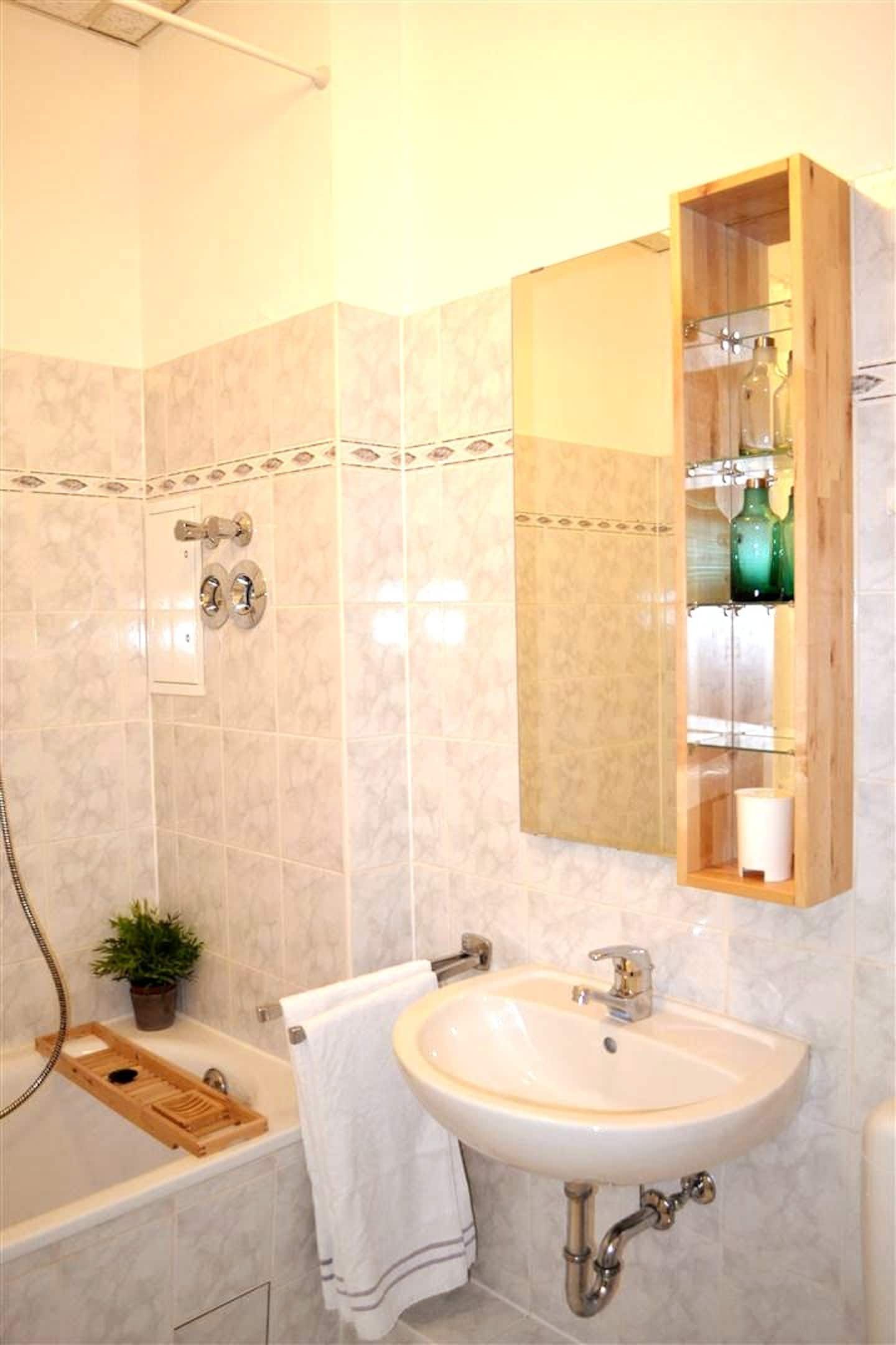 A bathroom with a sink a mirror and a bathtub  in our holiday apartment in Berlin close to the Mauerpark