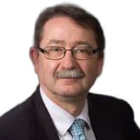 Man with glasses and mustache in a suit, smiling.