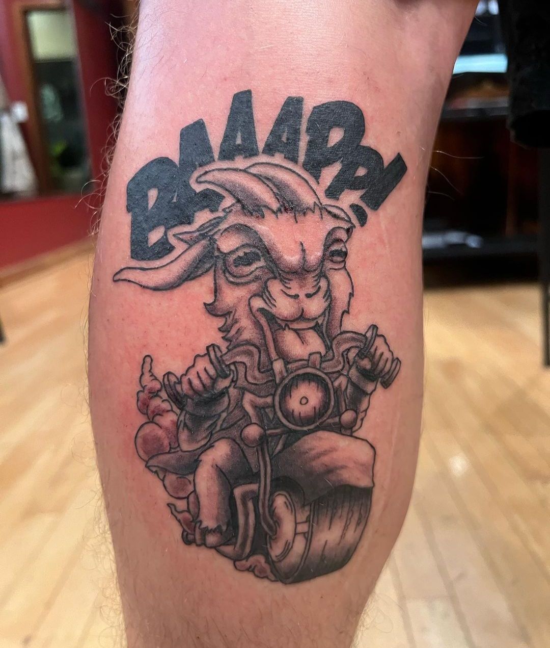 A man has a tattoo of a goat on his leg