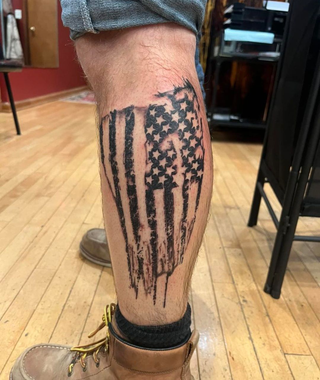 A man has a tattoo of an american flag on his leg.