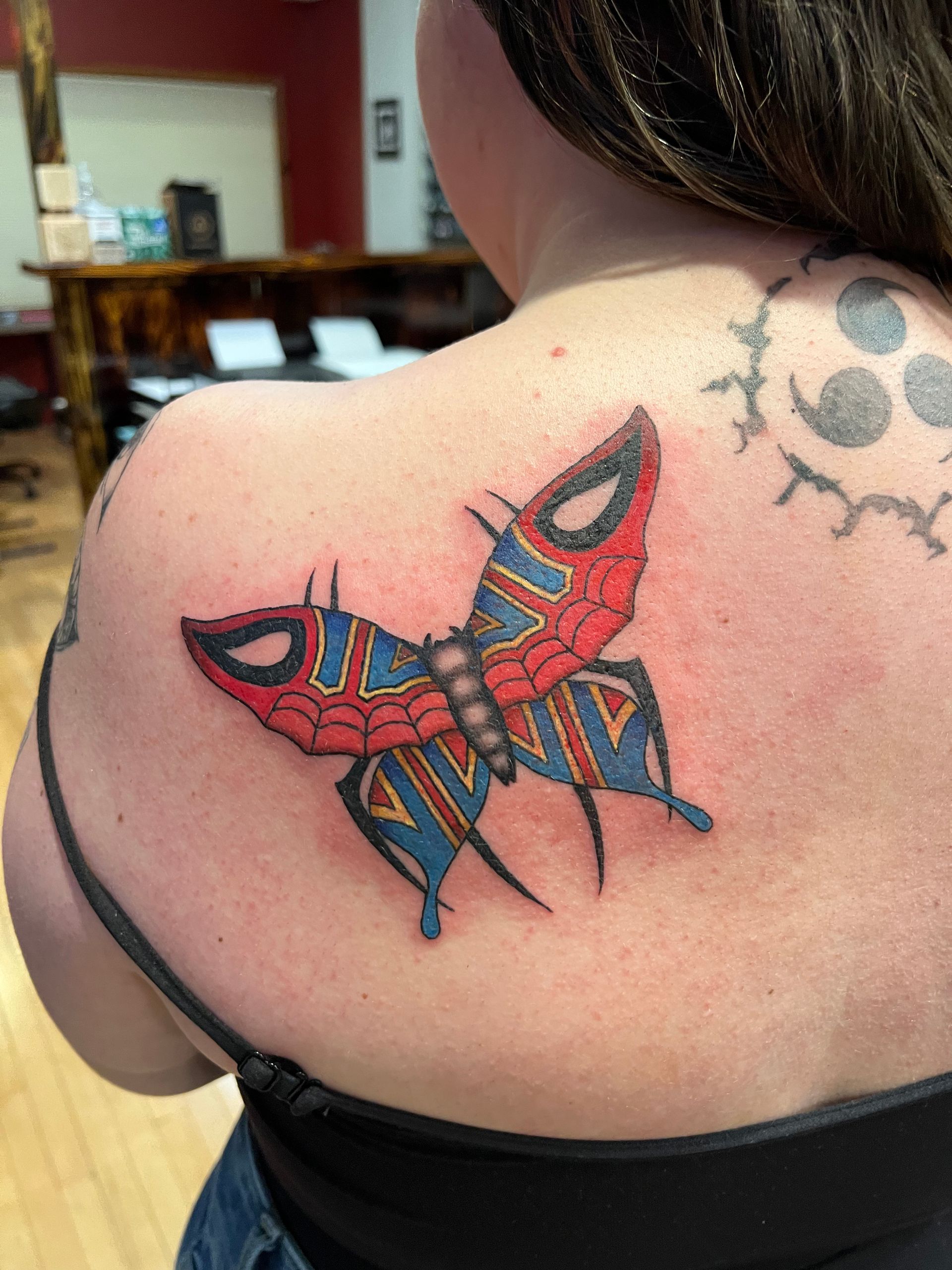 A man is getting a tattoo on a woman 's arm.