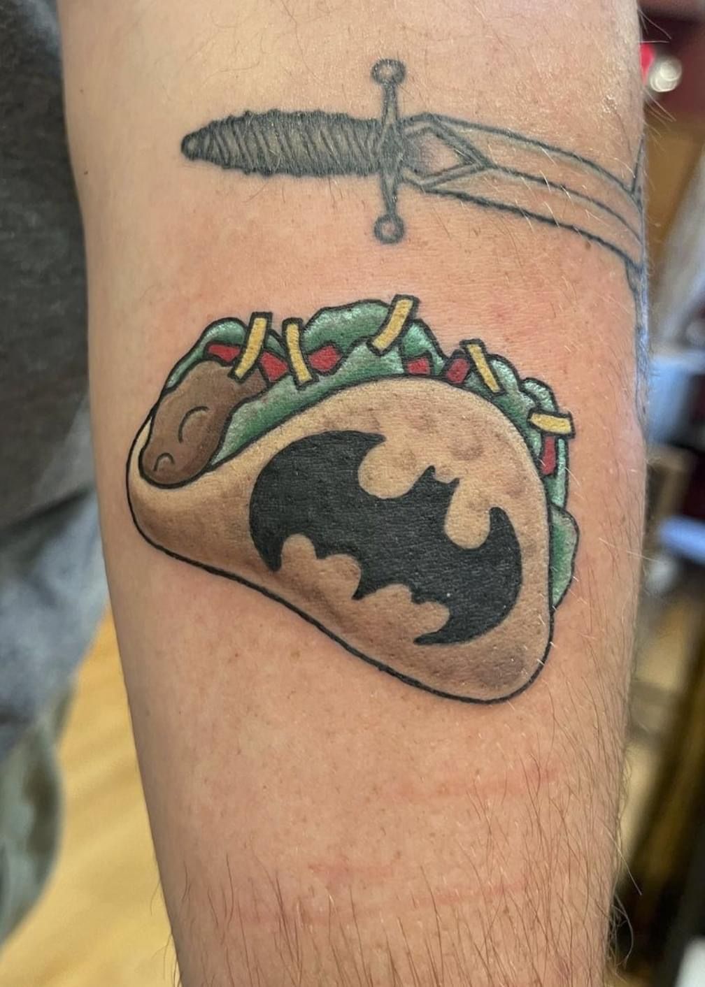 A person is getting a tattoo on their arm.