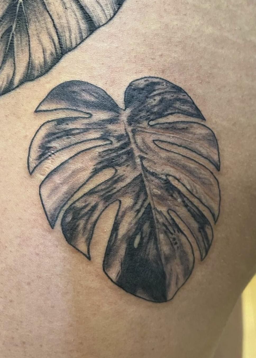 A close up of a person getting a tattoo on their arm.