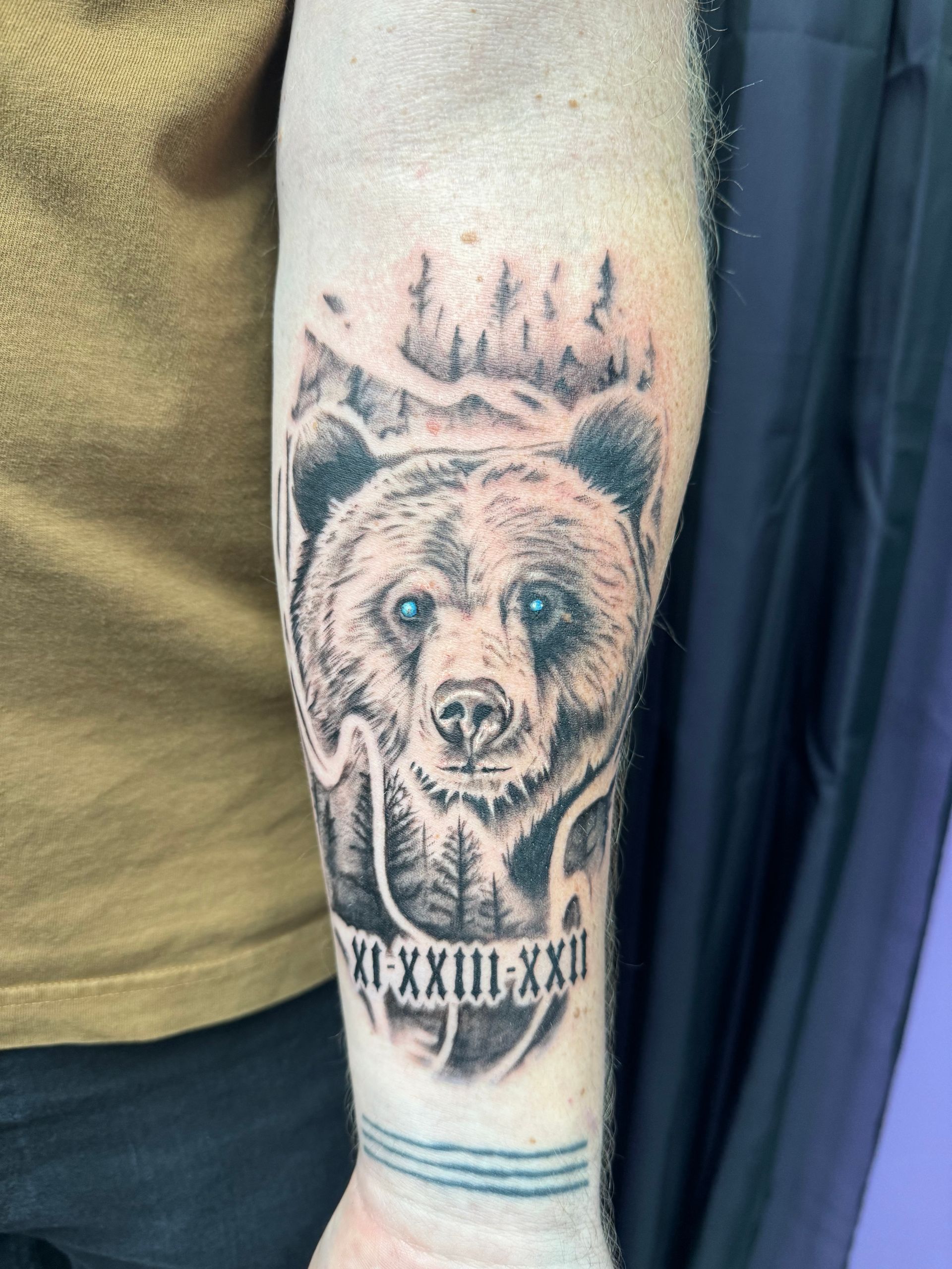 A man with two tattoos on his arms covering his face.