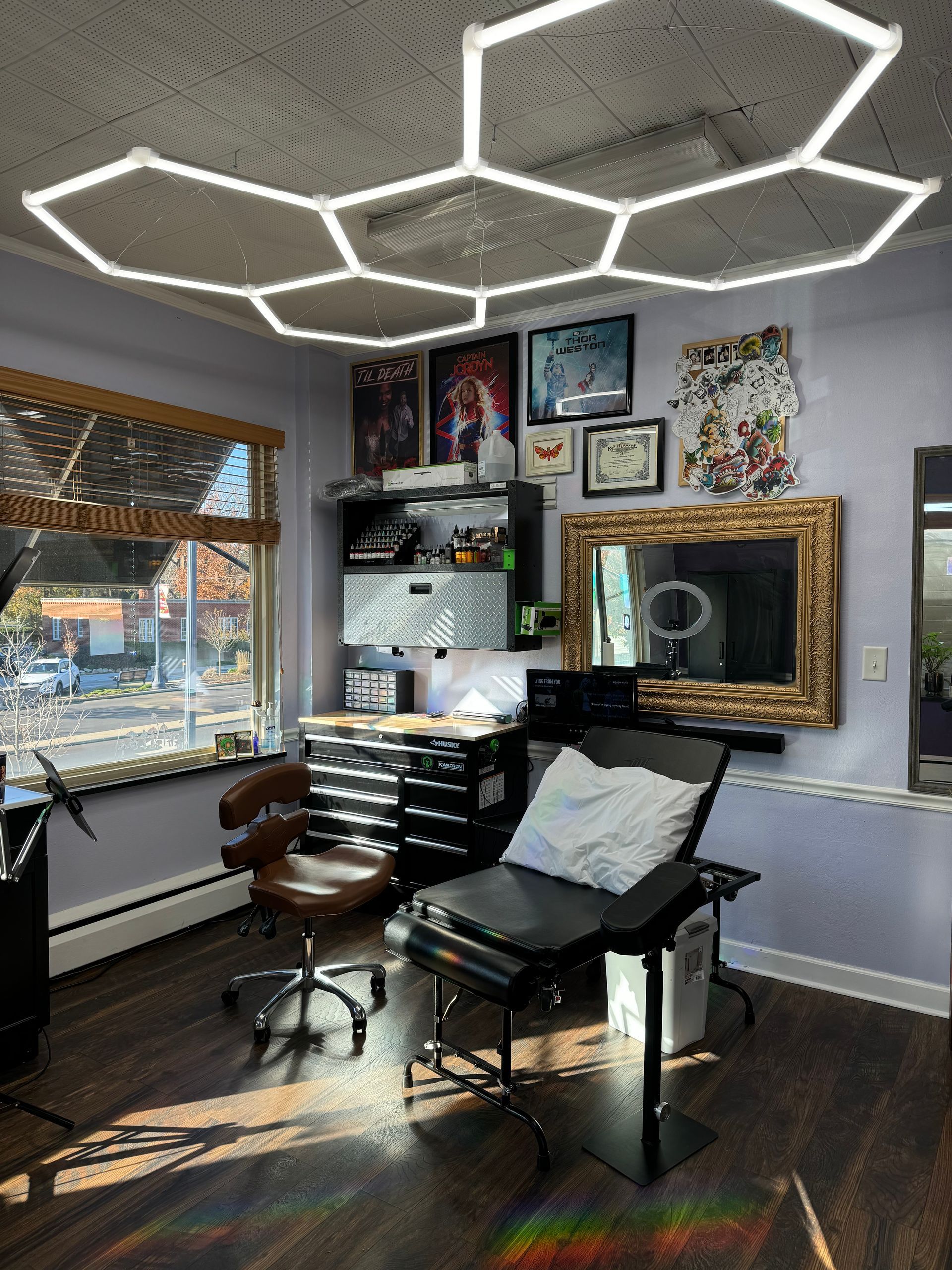 The man is wearing glasses and has a lot of tattoos on his arms.