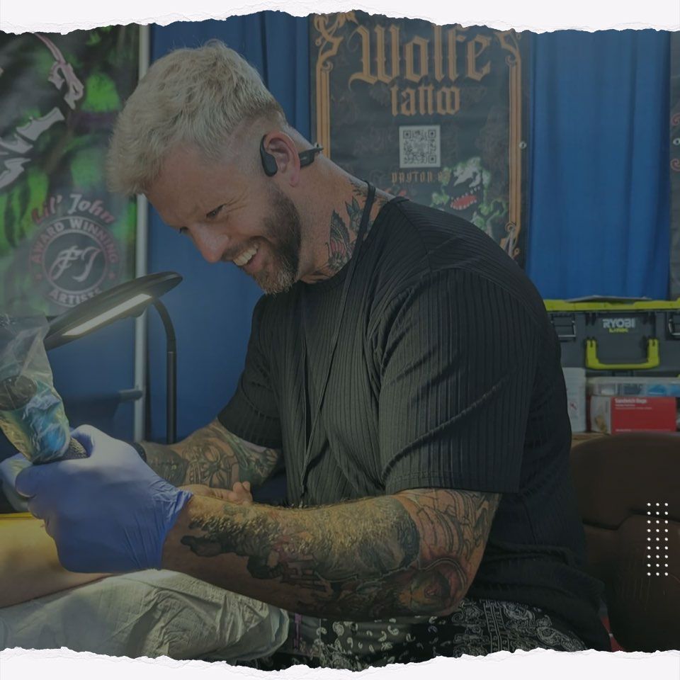 A man is getting a tattoo on another man 's arm.