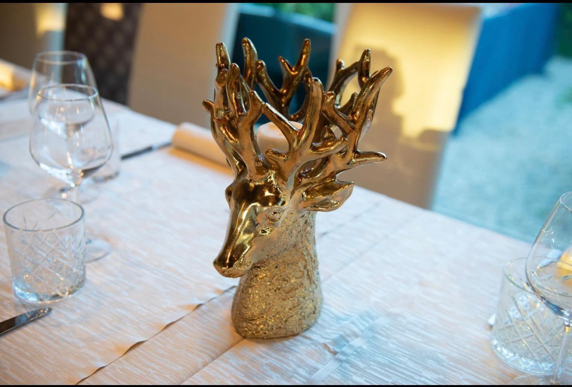 Una scultura a forma di testa di cervo color oro lucido, con grandi corn