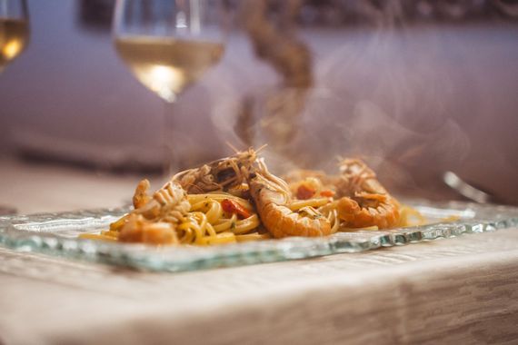 Sala elegante di un ristorante di mare con luci soffuse, tavoli apparecchiati e atmosfera raffinata e accogliente.