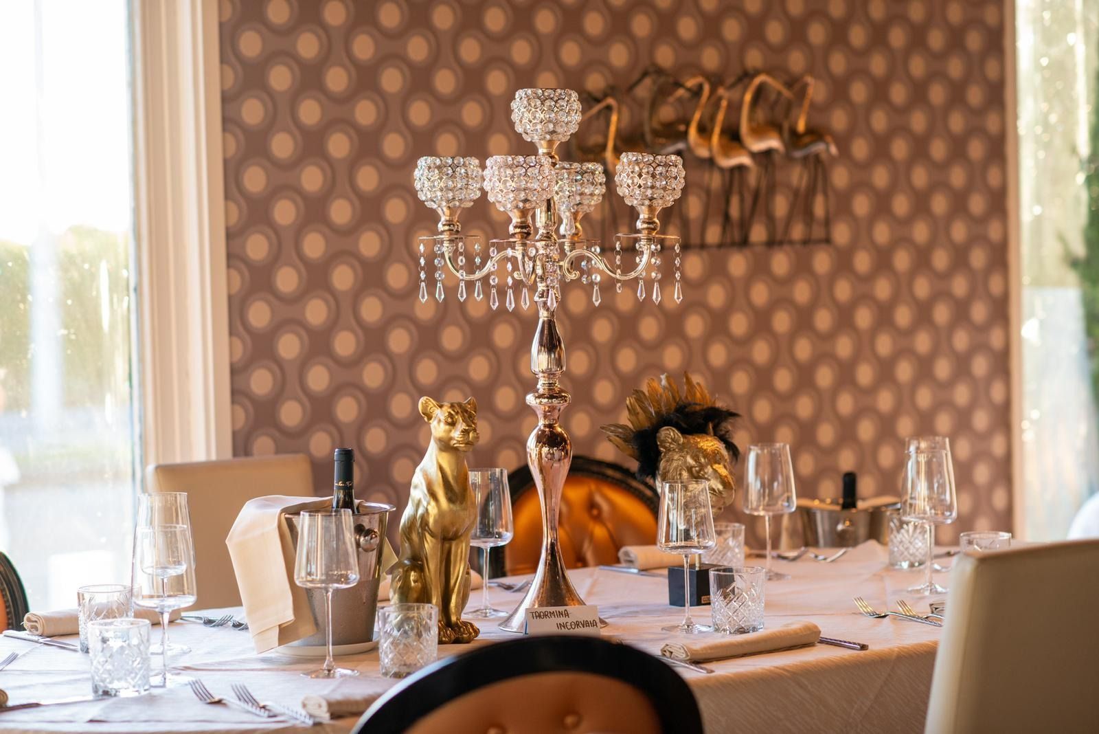 In una sala da pranzo con carta da parati a motivi decorativi, un candelabro di cristallo