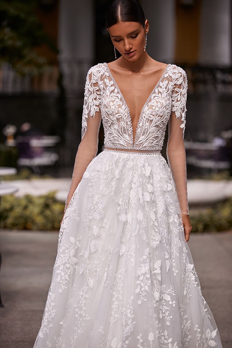 Eine Frau trägt ein weißes Brautkleid mit tiefem Ausschnitt.