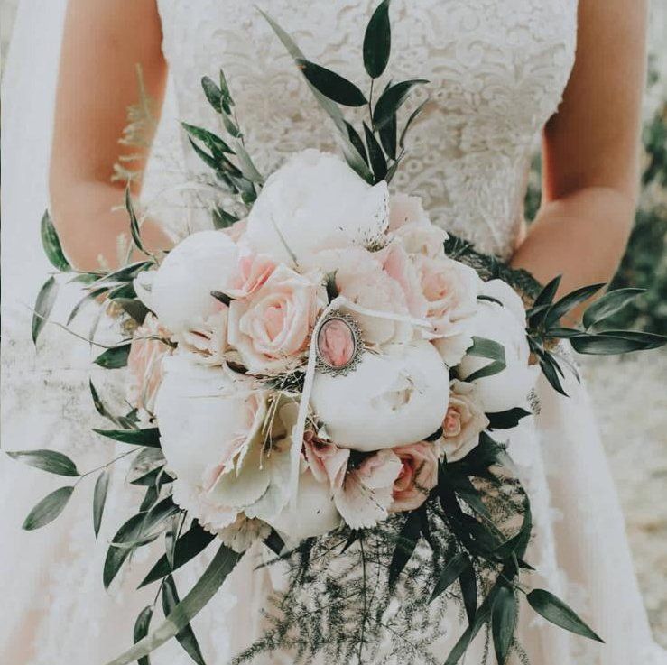 Eine Braut in einem weißen Kleid hält einen Blumenstrauß