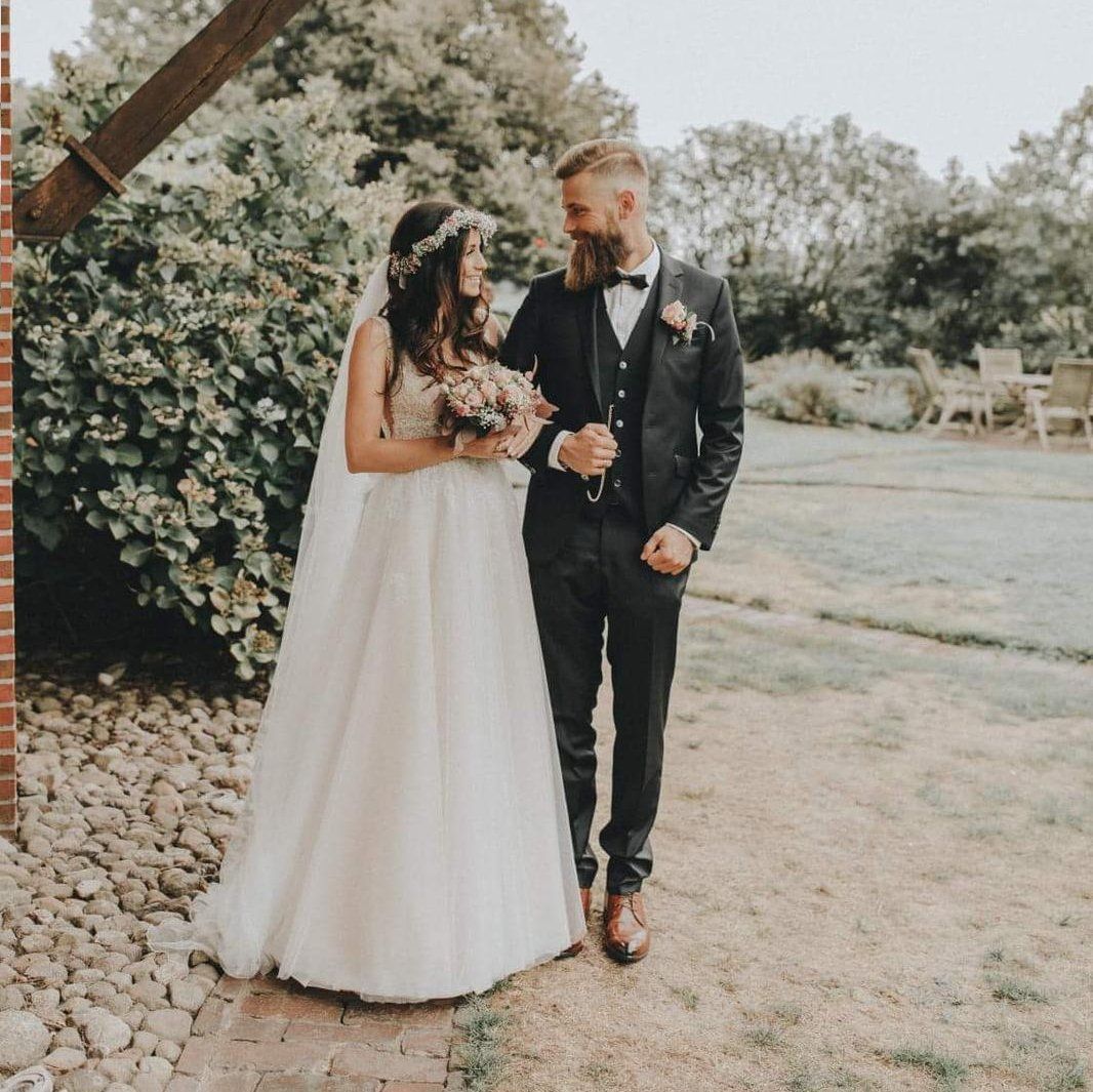 Eine Braut und ein Bräutigam stehen an ihrem Hochzeitstag nebeneinander