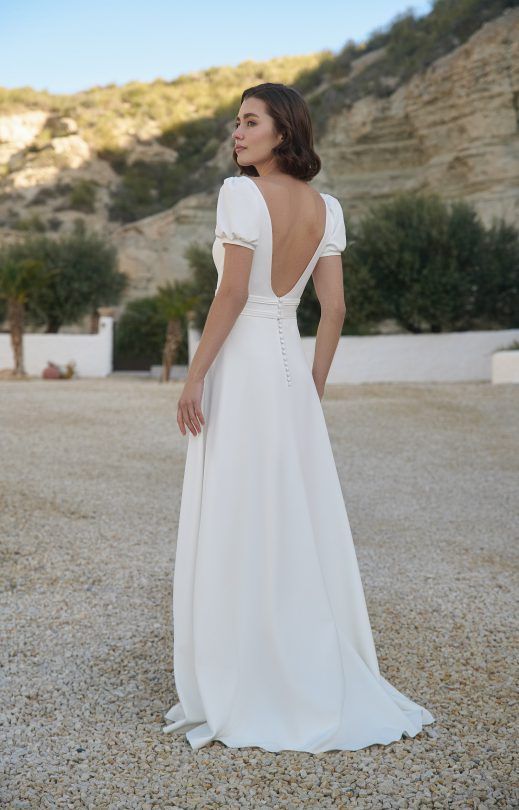 Zu sehen ist der Rücken einer Frau in einem weißen Brautkleid.