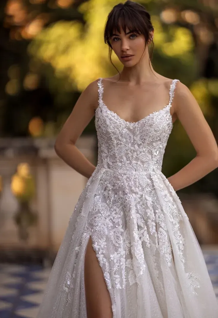 Eine Frau trägt ein weißes Brautkleid mit hohem Schlitz.