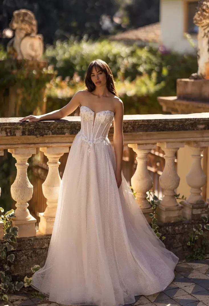 Eine Frau in einem Brautkleid steht neben einem Geländer.