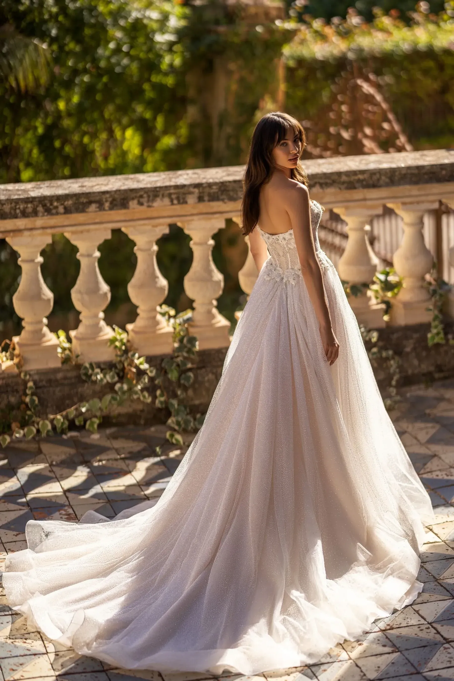 Eine Frau in einem Brautkleid steht neben einem Geländer.