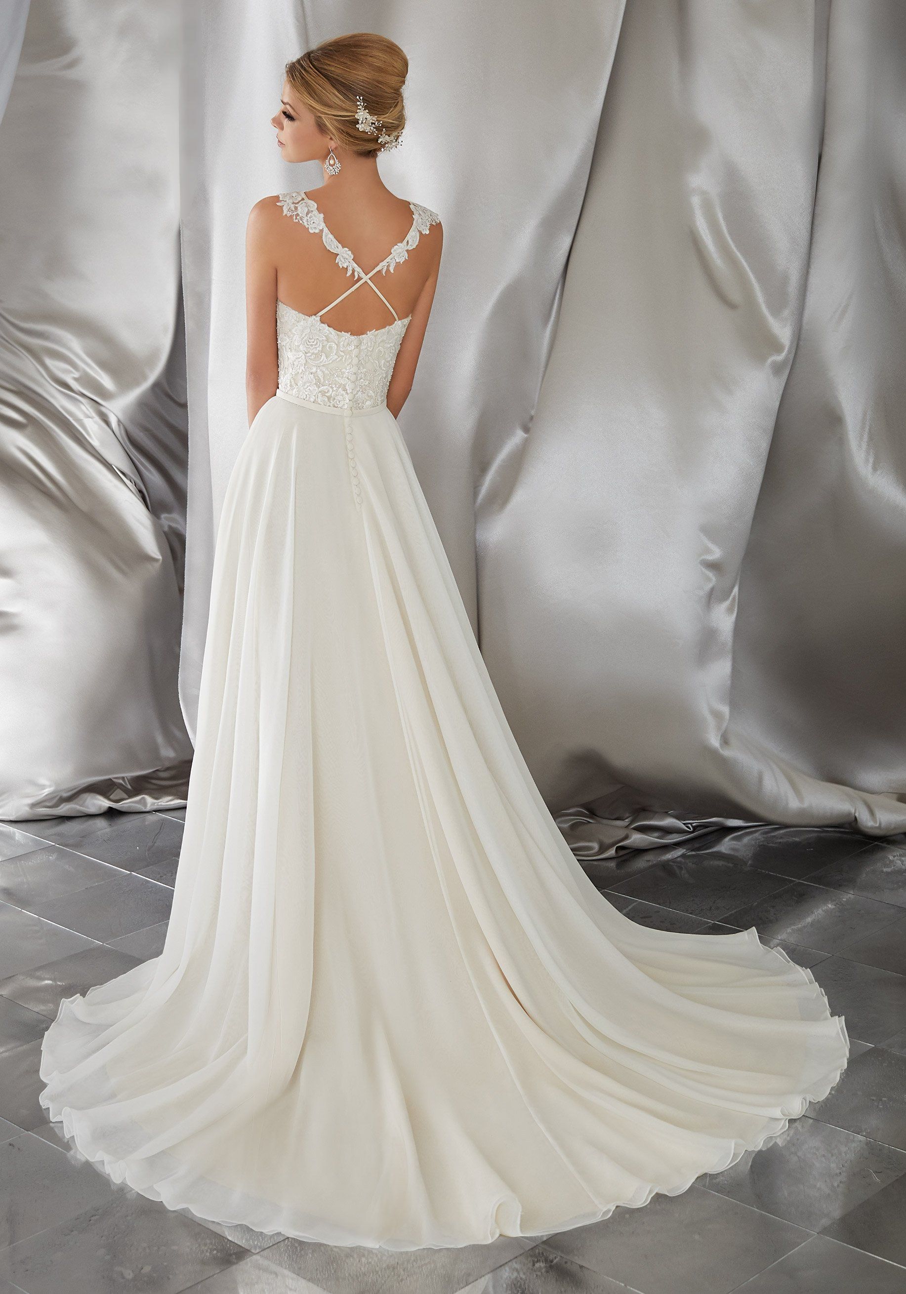 Eine Frau trägt ein weißes Brautkleid mit langer Schleppe