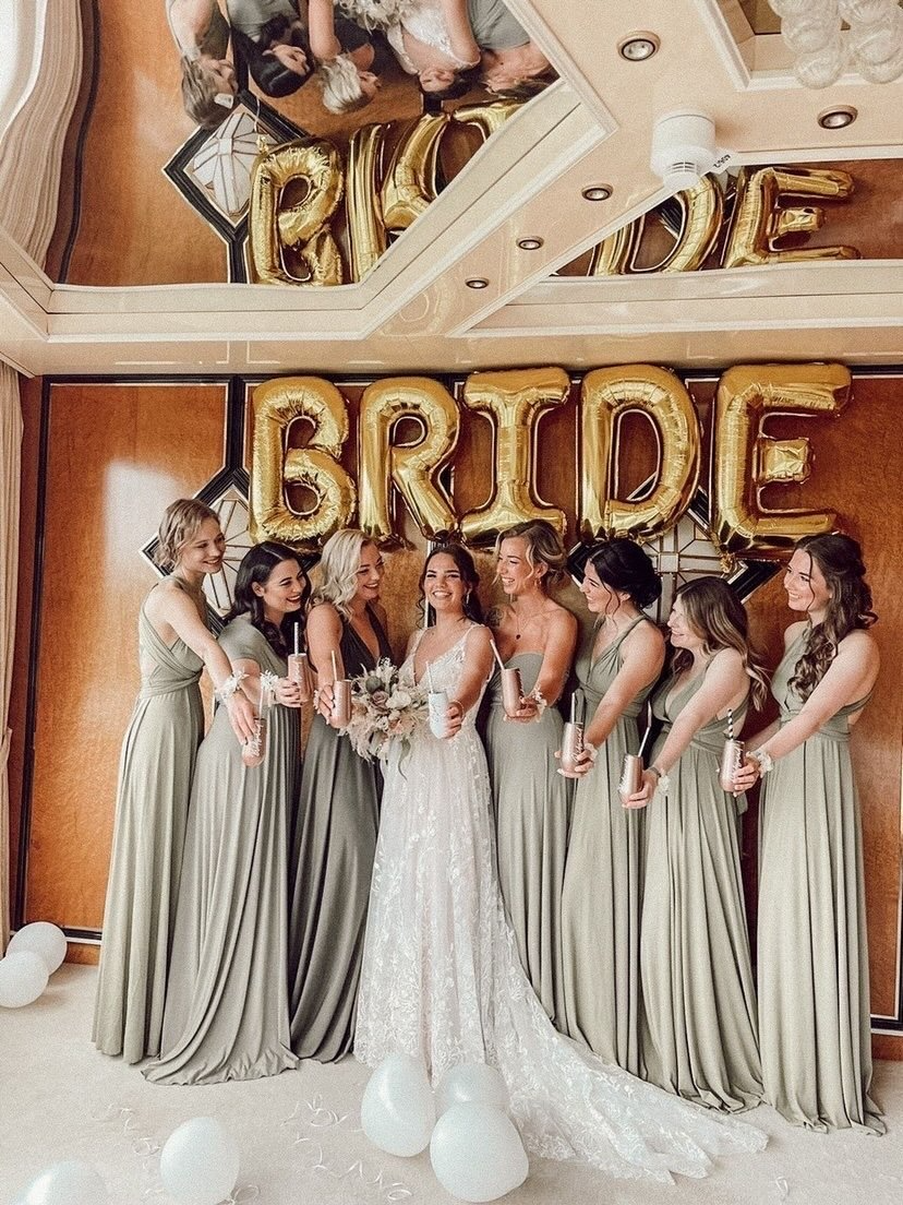 Eine Braut und ihre Brautjungfern posieren für ein Foto vor einem Schild mit der Aufschrift „Braut“.