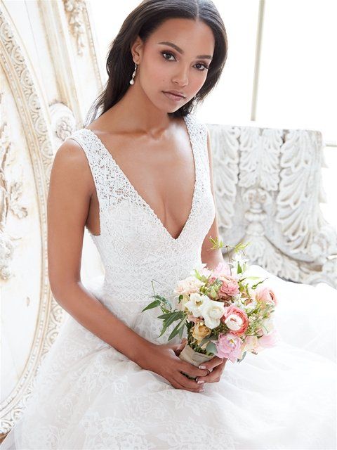 Eine Frau in einem Brautkleid hält einen Blumenstrauß