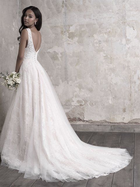 Eine Frau in einem weißen Brautkleid hält einen Blumenstrauß.