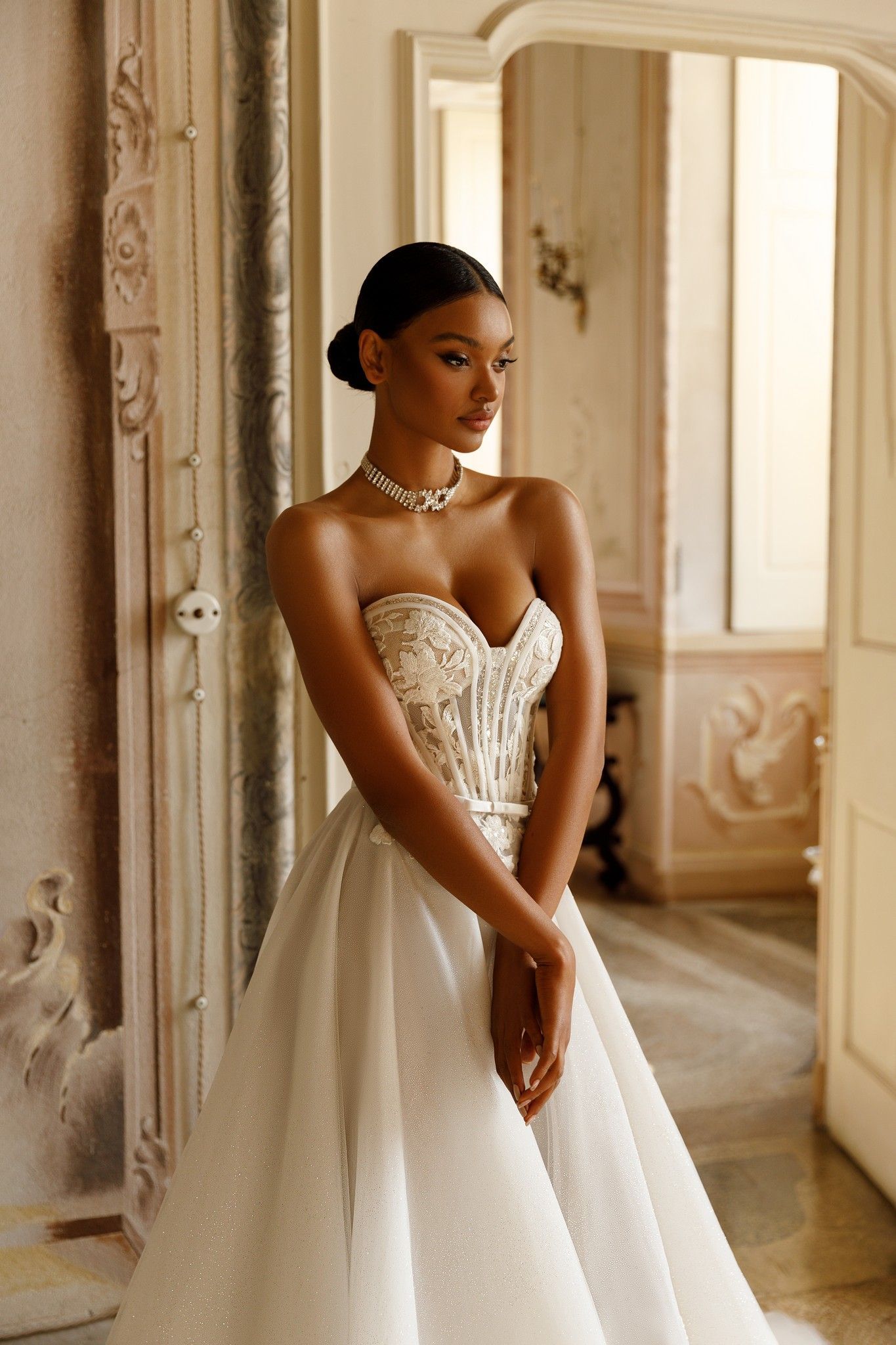 Eine Frau in einem Brautkleid steht vor einer Tür.