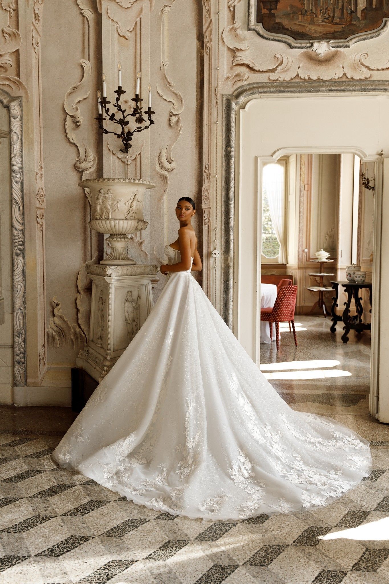 Eine Frau in einem langen weißen Brautkleid steht in einem Raum.