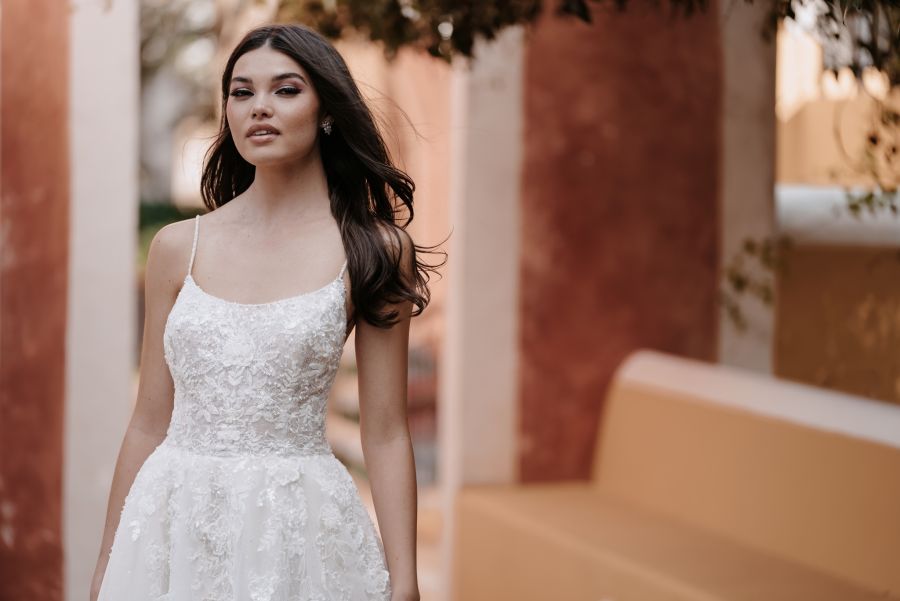 Eine Frau in einem Brautkleid steht vor einem Gebäude.