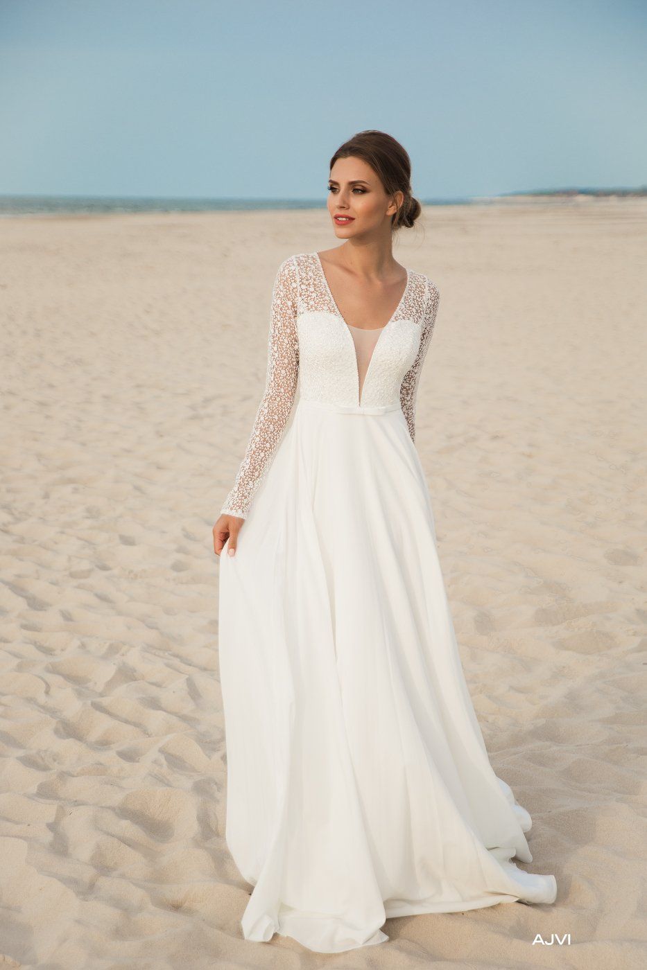 Eine Frau in einem weißen Brautkleid steht an einem Strand.