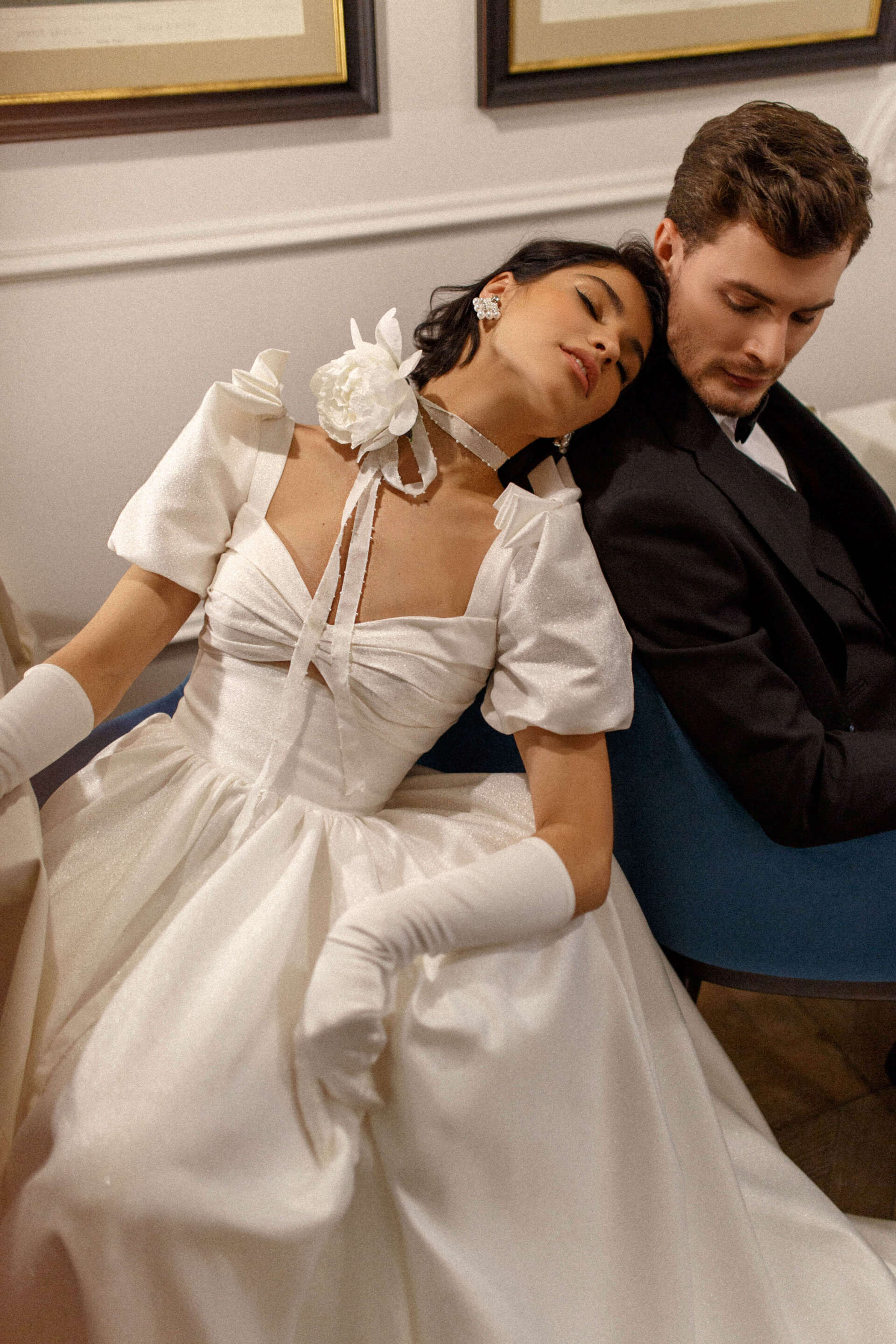 Eine Frau im Brautkleid sitzt neben einem Mann im Smoking.