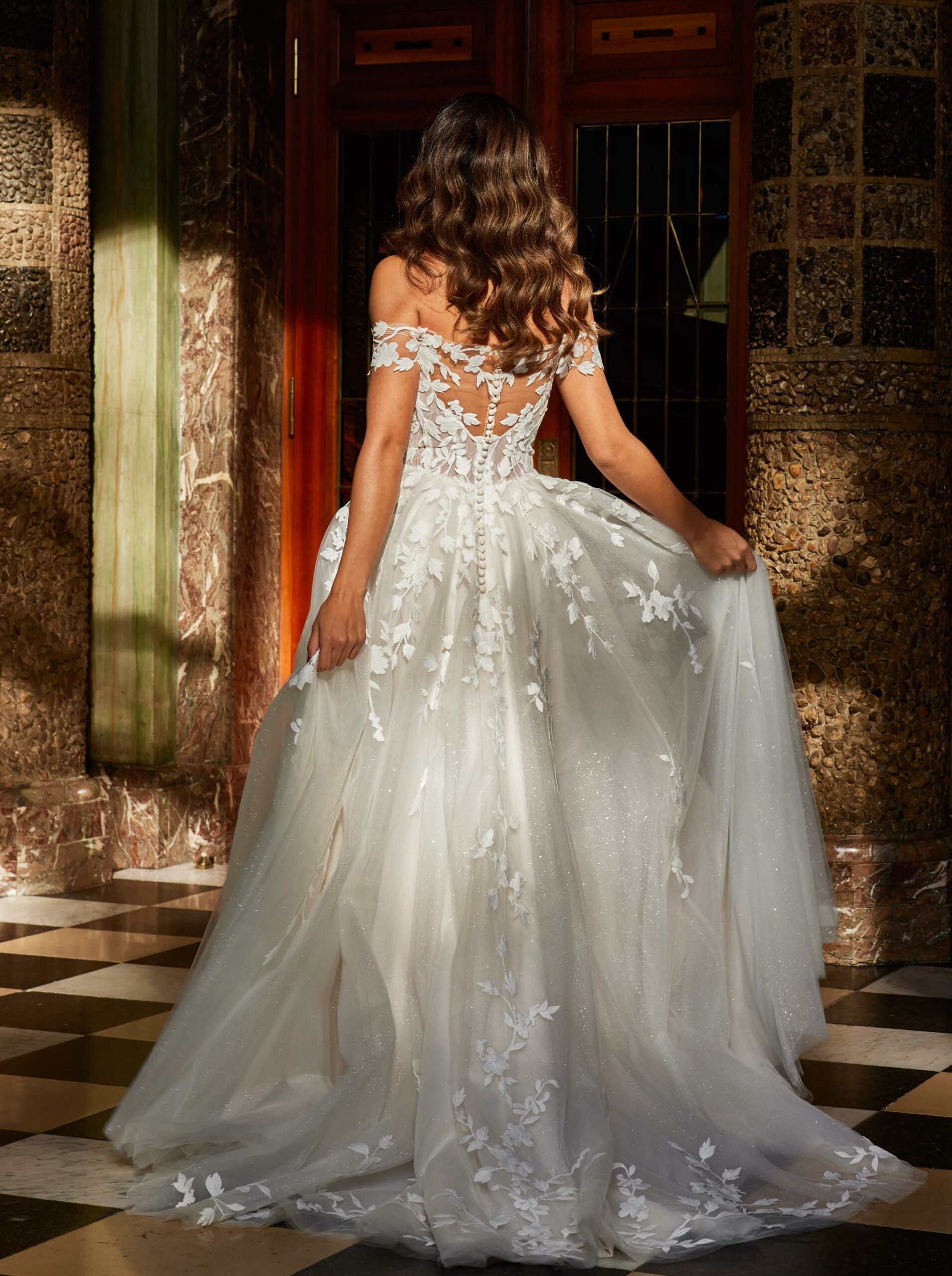 Zu sehen ist der Rücken einer Frau im Brautkleid.