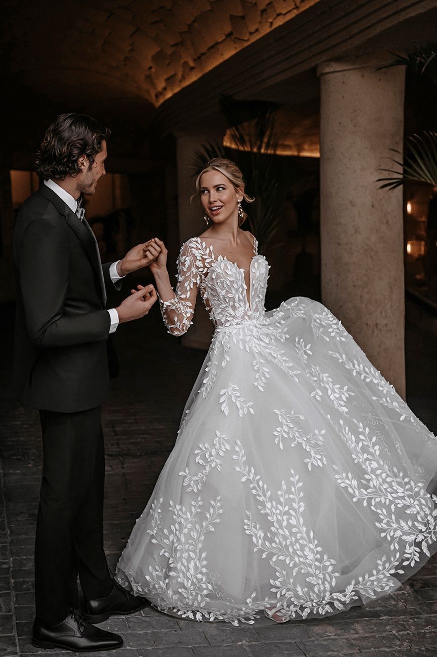 Eine Braut und ein Bräutigam posieren für ein Foto, während die Braut ein Brautkleid trägt.