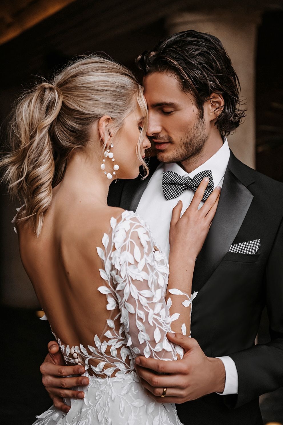 Eine Braut und ein Bräutigam umarmen sich und schauen sich in die Augen.