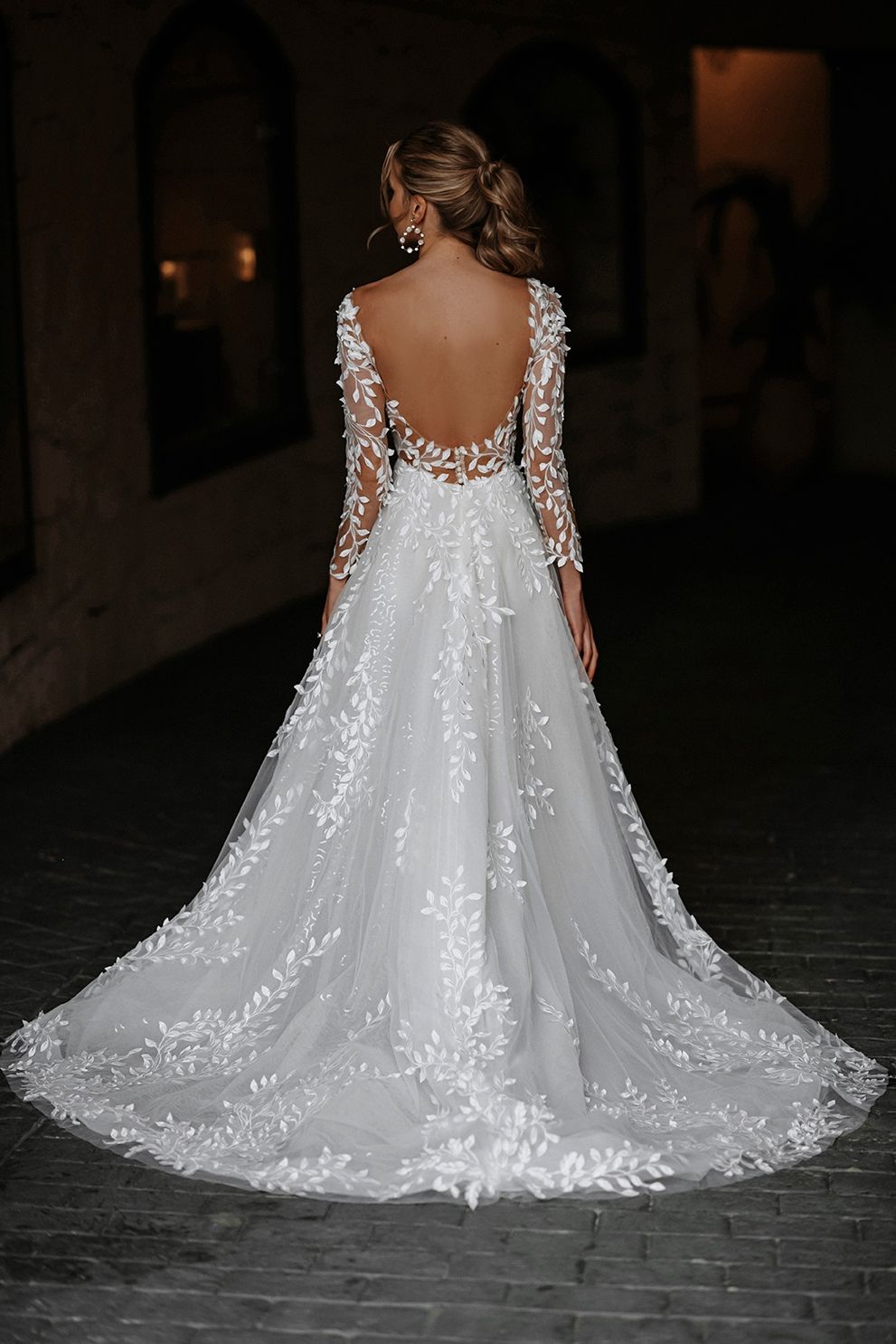 Die Rückseite eines Brautkleides mit langen Ärmeln und V-Ausschnitt.