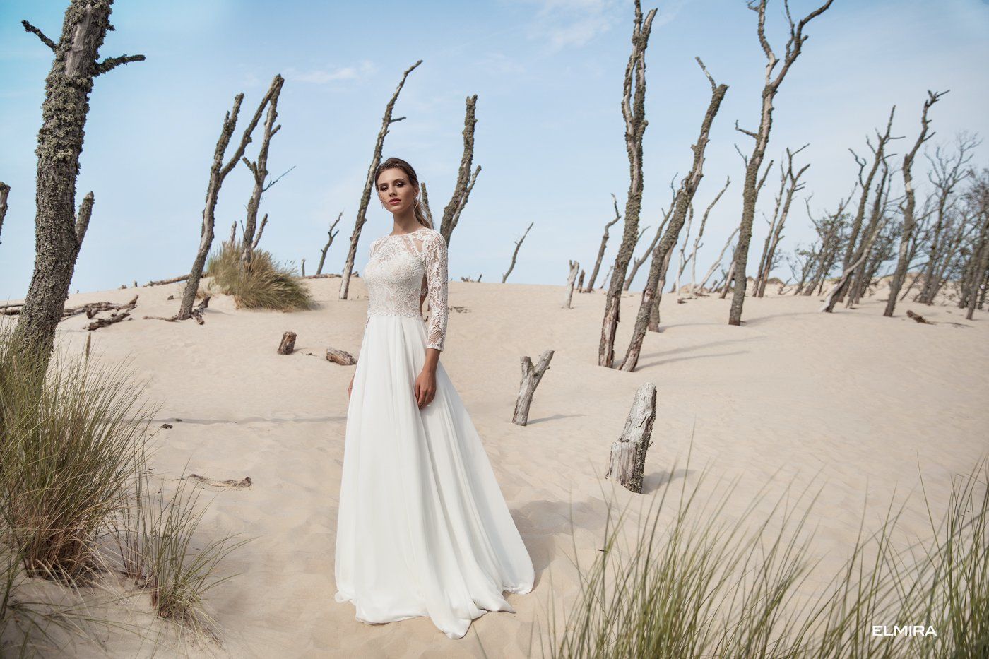 Eine Frau in einem Brautkleid steht mitten in einer Wüste.