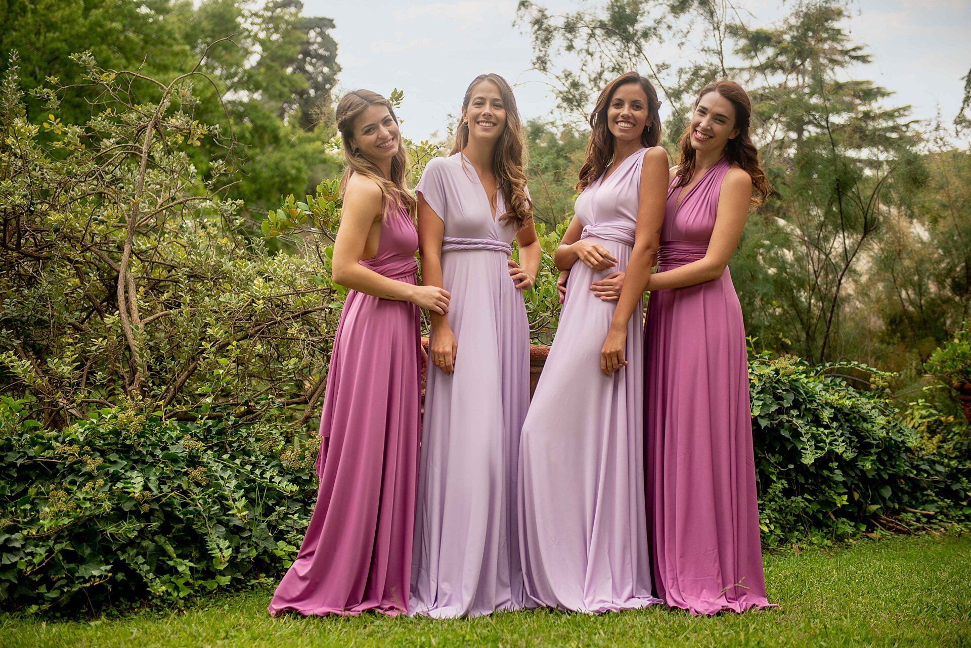 Eine Gruppe von Frauen in lila Kleidern posiert für ein Foto.