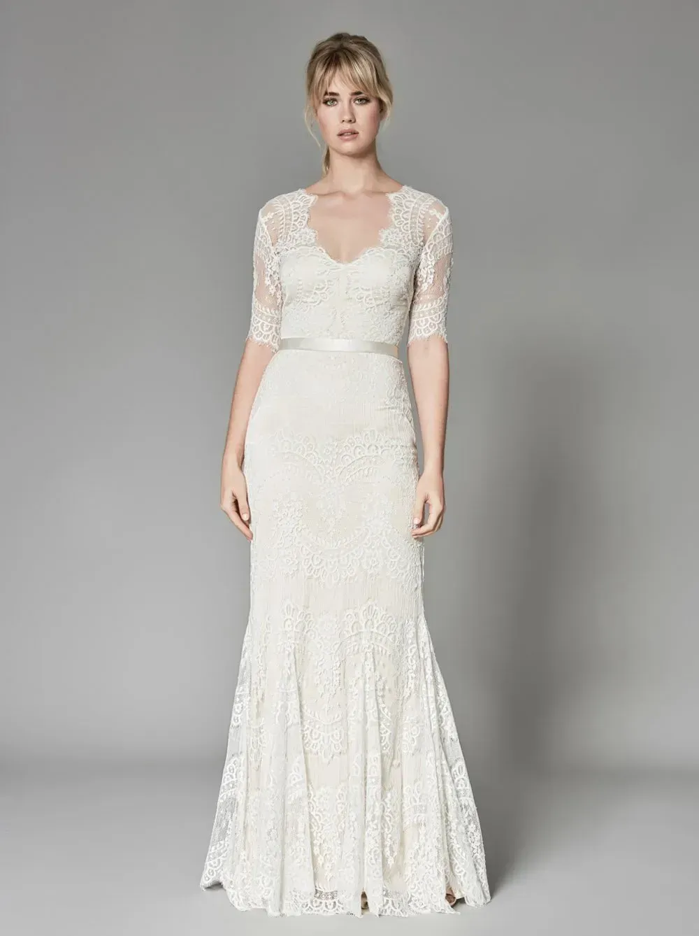 Eine Frau trägt ein weißes Brautkleid aus Spitze.