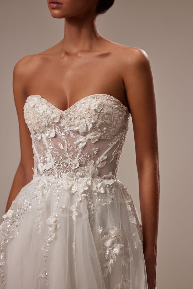 Eine Frau trägt ein weißes trägerloses Brautkleid.