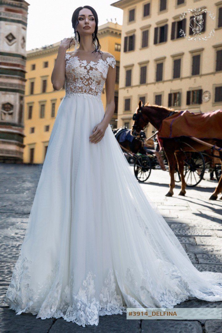 Eine Frau in einem weißen Brautkleid steht vor einer Pferdekutsche.