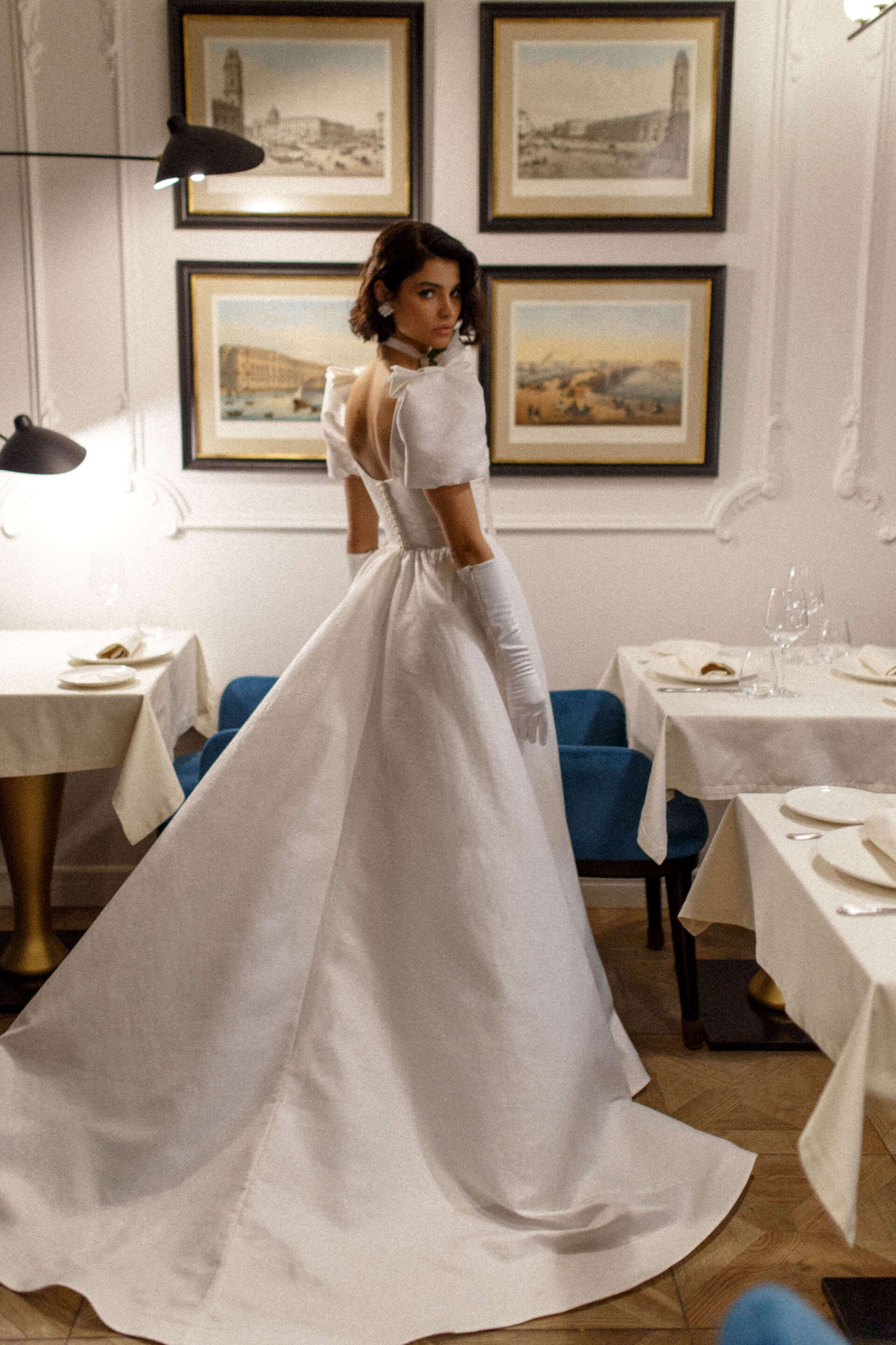 Eine Frau in einem weißen Brautkleid steht in einem Restaurant.