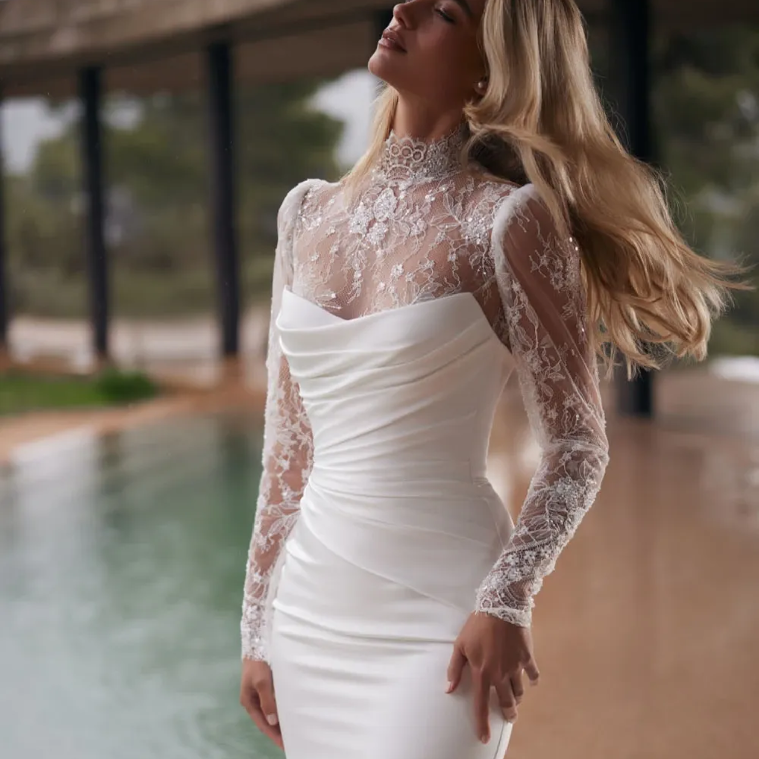 Eine Frau in einem weißen Brautkleid steht auf einem Felsen in der Nähe des Wassers.