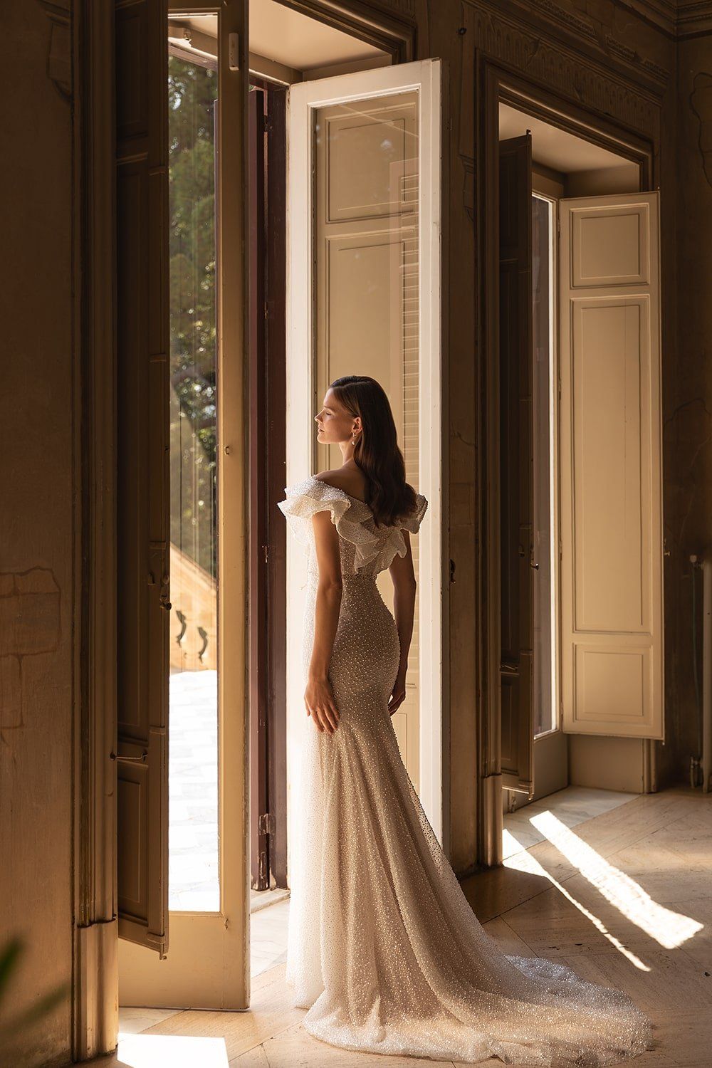 Eine Frau in einem Brautkleid steht vor einer Tür.