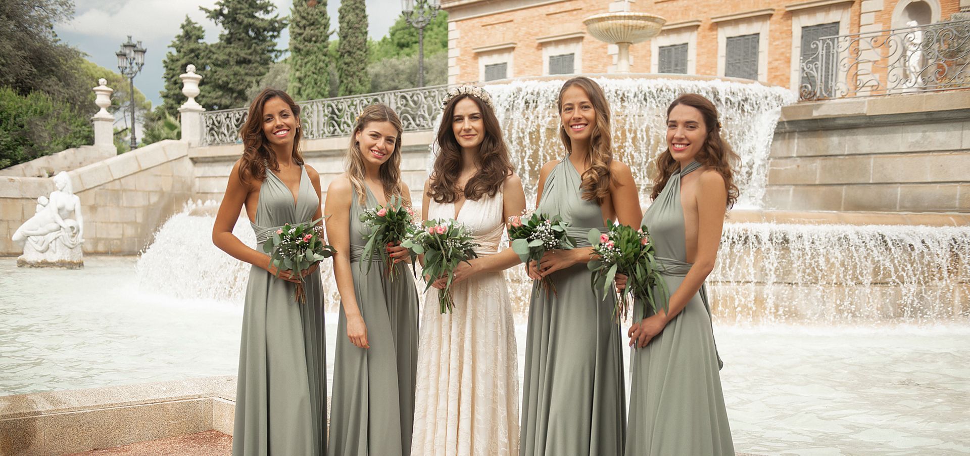 Eine Braut und ihre Brautjungfern posieren für ein Foto vor einem Wasserfall.
