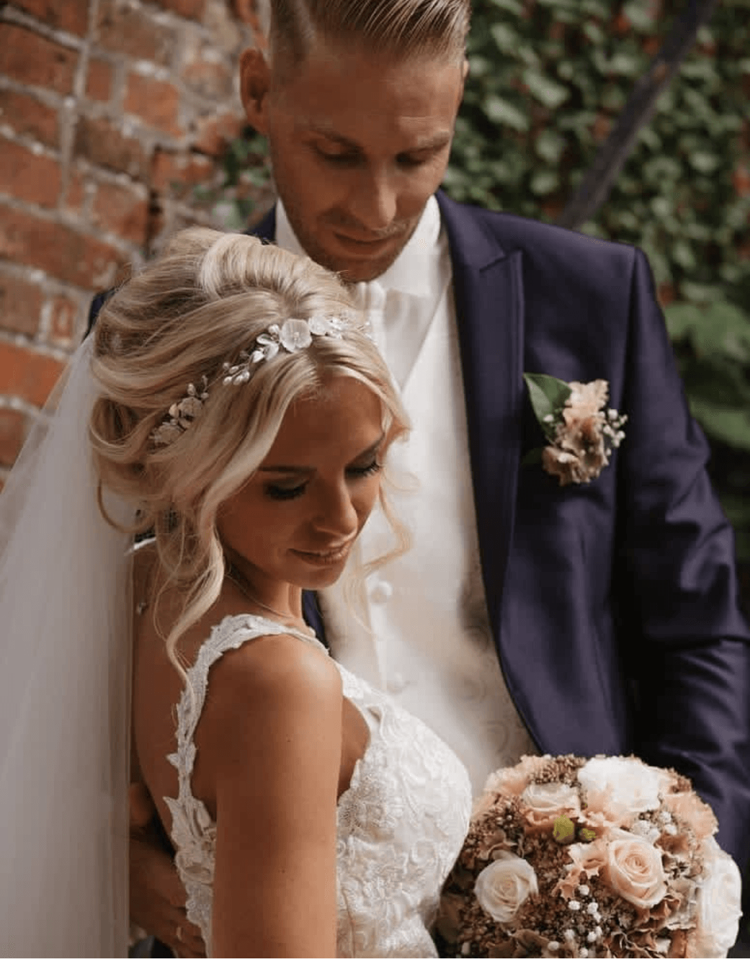 Eine Braut und ein Bräutigam posieren für ein Foto, während die Braut einen Blumenstrauß hält.